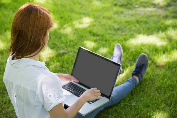 Ruiva usando seu laptop no parque — Fotografia de Stock