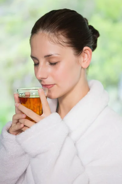 Beautiful woman in bathrobe having tea — Stock Photo, Image