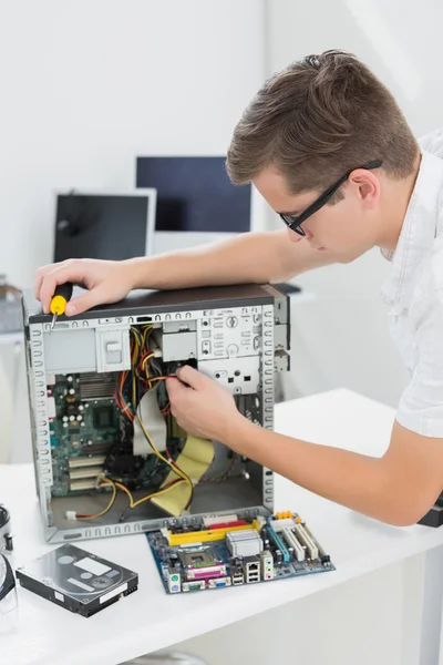 Junger Techniker arbeitet an kaputtem Computer — Stockfoto