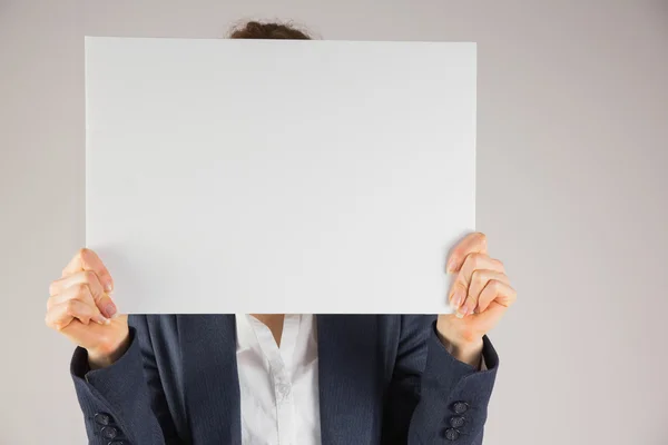 Empresaria sosteniendo tarjeta sobre la cara — Foto de Stock