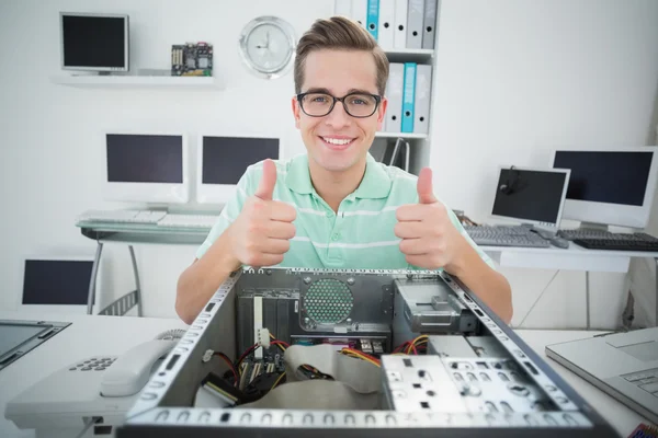 Técnico sorrindo trabalhando em computador quebrado — Fotografia de Stock