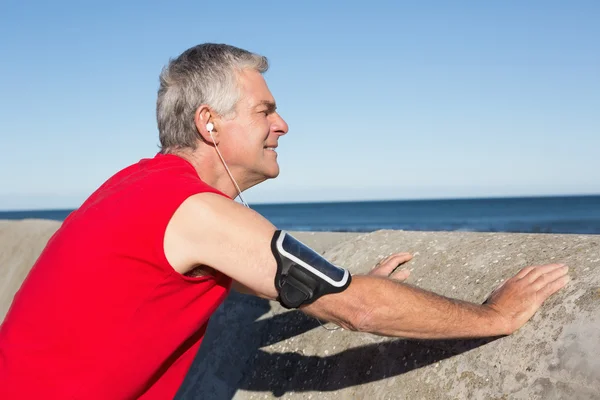 Actieve senior man die zich uitstrekt voordat een jog — Stockfoto