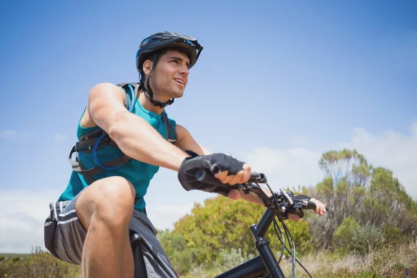 Athletic young man mountain biking — Stock Photo, Image