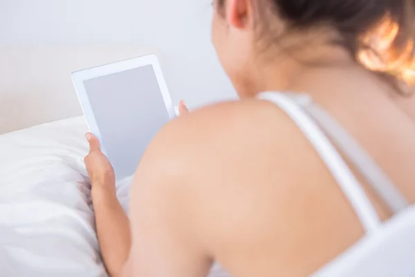 Avslappnad kvinna med digital tablet i sängen — Stockfoto