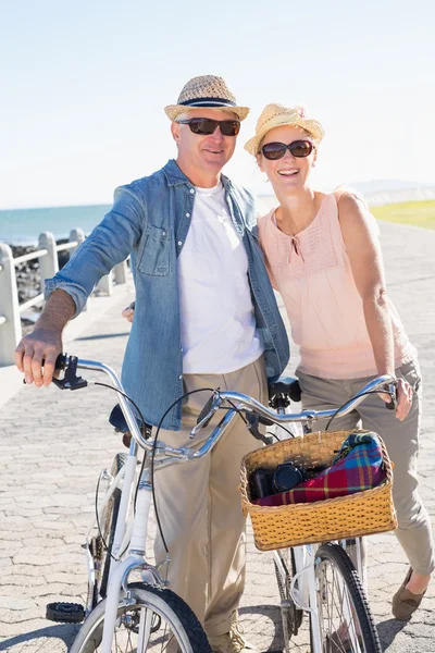 Happy casual couple going for a bike ride on the pier — Stock Photo, Image