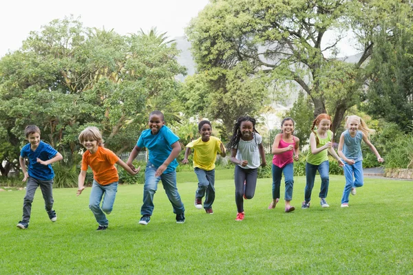 Ученики бегают по траве снаружи — стоковое фото