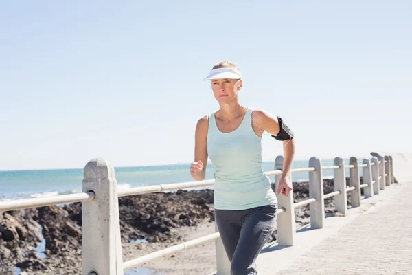 Fitte reife Frau joggt auf dem Pier — Stockfoto