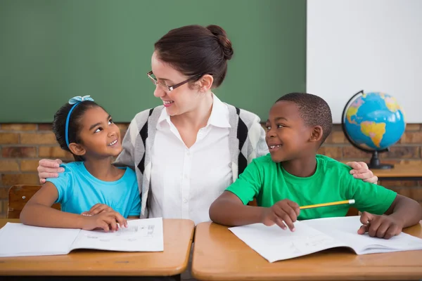Pupils and teacher smiling at each other — Stock Photo, Image