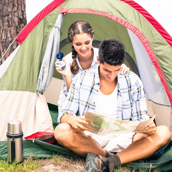 Couple looking at map outside their tent — Stock Photo, Image