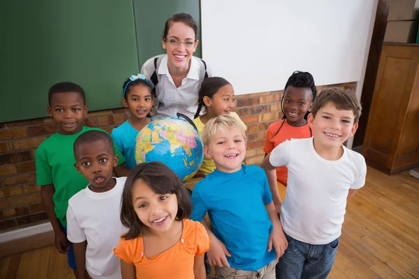 Pupils around a globe with teacher — Stock Photo, Image