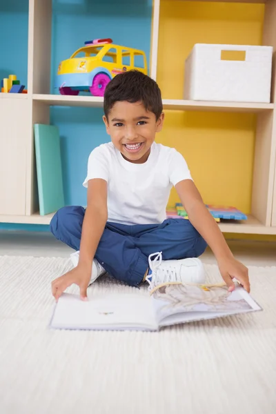 Junge liest im Klassenzimmer auf dem Boden — Stockfoto