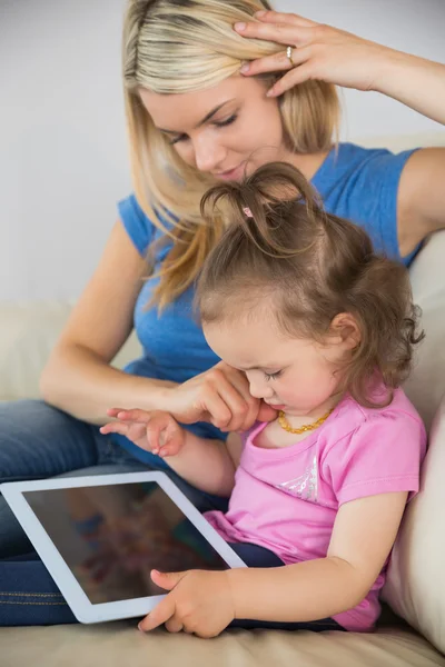 Madre e hija usando tableta digital en el sofá —  Fotos de Stock