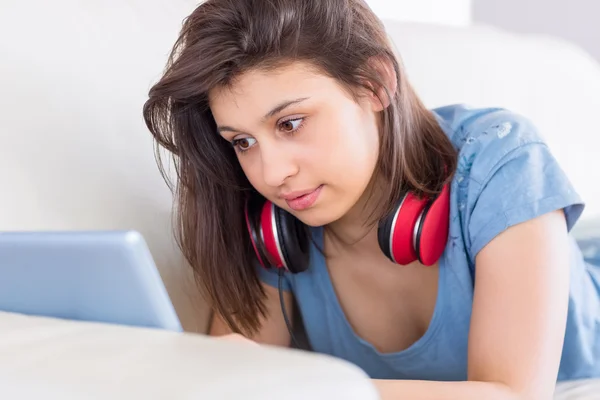 Hübsche Brünette mit Tablet-PC auf der Couch — Stockfoto