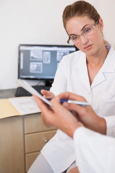 Dentista y asistente estudiando rayos X en la computadora — Foto de Stock