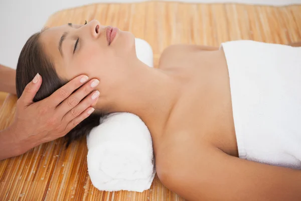 Beautiful brunette enjoying head massage — Stock Photo, Image