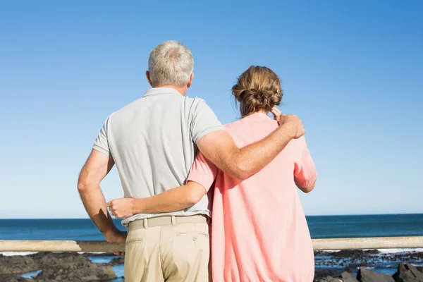 Happy casual couple looking out to sea — Stock Photo, Image