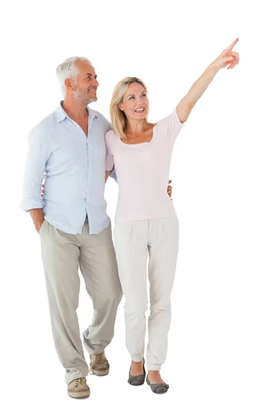 Smiling couple walking and pointing — Stock Photo, Image