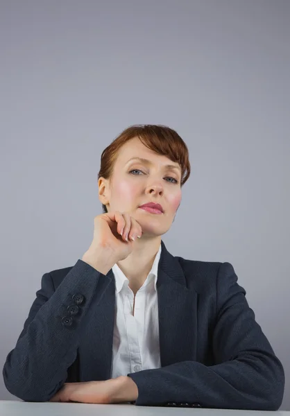 Seriöse Geschäftsfrau sitzt am Schreibtisch — Stockfoto