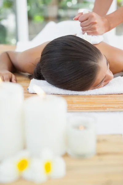 Brünette genießt Kräuterkompresse Massage — Stockfoto