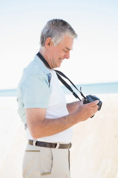 Lycklig senior man tittar på sin kamera — Stockfoto