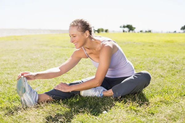 Passen volwassen vrouw warming-up op het gras — Stockfoto