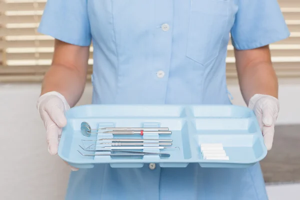 Dental assistant in blue holding tray of tools — Stock Photo, Image
