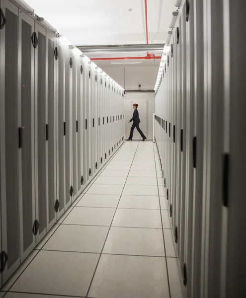 Техник, идущий по серверному коридору — стоковое фото
