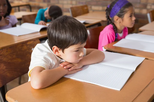 Bored pupil sitting at his desk — Stock Photo, Image