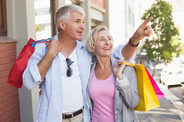 Glückliches älteres Paar spaziert mit seinen Einkäufen — Stockfoto