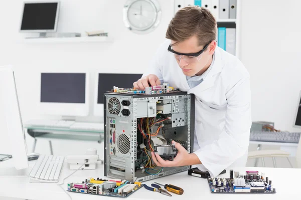 Jovem técnico trabalhando em computador quebrado — Fotografia de Stock