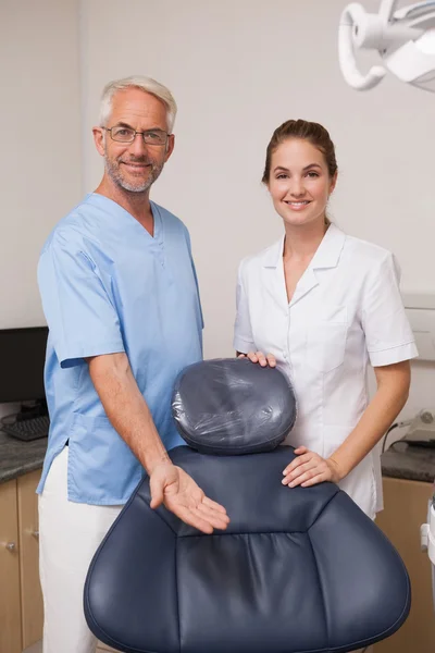 Dentista e assistente sorrindo para a câmera — Fotografia de Stock