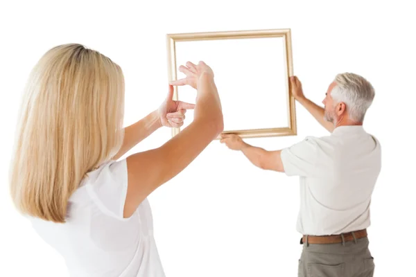 Couple hanging a frame together — Stock Photo, Image