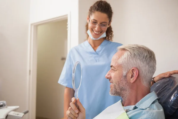 Dentista mostrando paziente il suo nuovo sorriso — Foto Stock