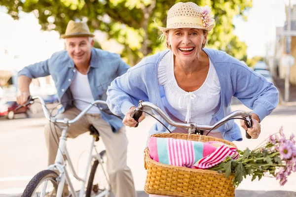 Feliz casal maduro indo para um passeio de bicicleta na cidade — Fotografia de Stock