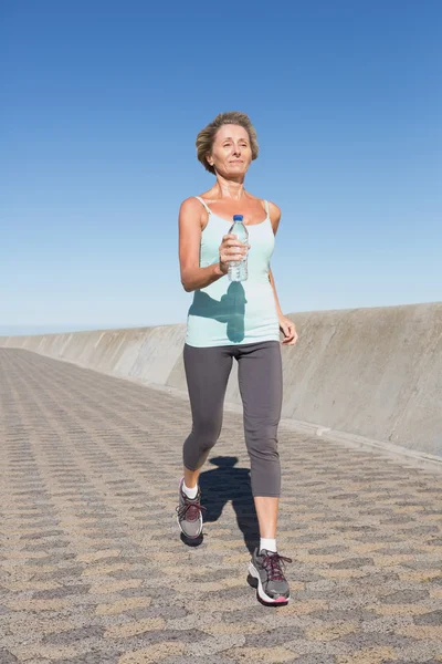 Aktiv senior kvinna jogging på piren — Stockfoto