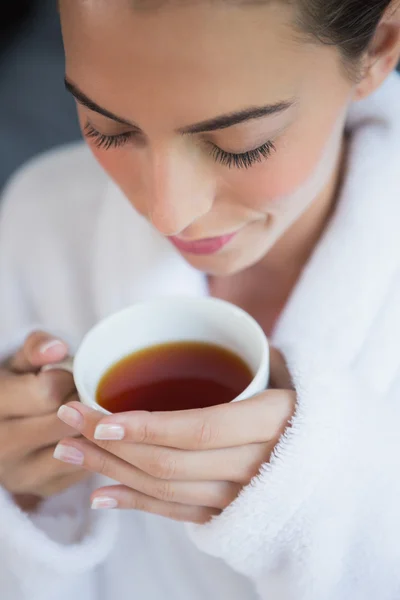Красивая женщина в халате пьет чай — стоковое фото