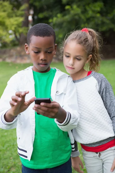 Niños pequeños mirando el teléfono inteligente —  Fotos de Stock