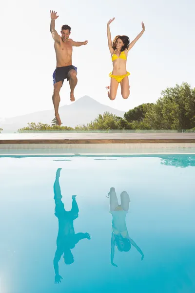 Pareja saltando en la piscina — Foto de Stock