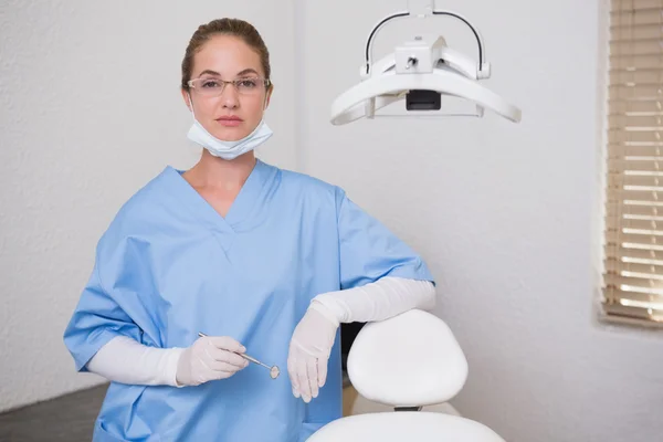 Dentista en uniforme azul mirando a la cámara — Foto de Stock