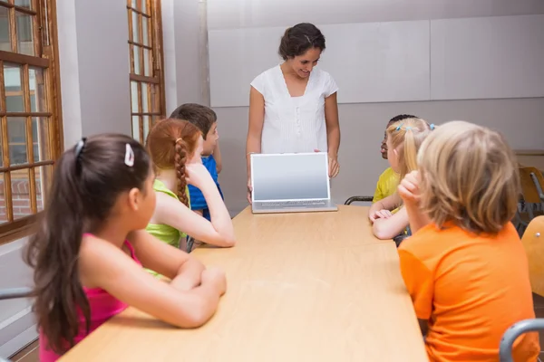 Teacher showing laptop to pupils — Stock Photo, Image