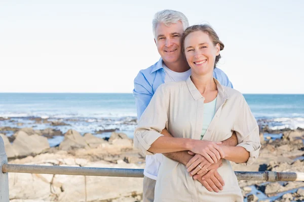 Happy casual couple hugging by the coast — Stock Photo, Image