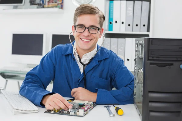 Lachende technicus luisteren naar cpu met stethoscoop — Stockfoto