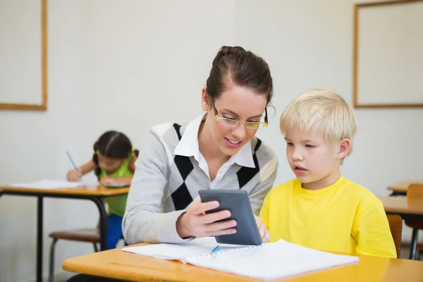 Teacher helping pupil in classroom — Stock Photo, Image