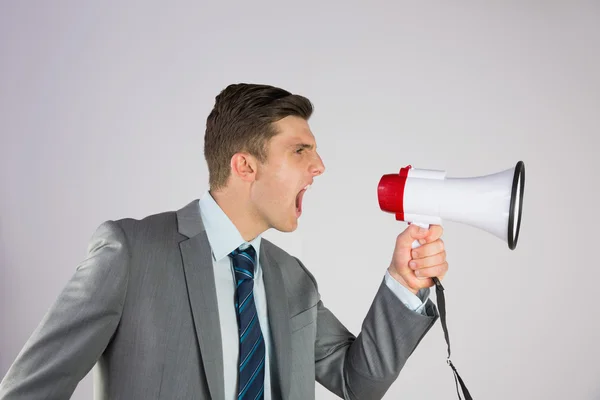 Homem de negócios irritado gritando através de megafone — Fotografia de Stock