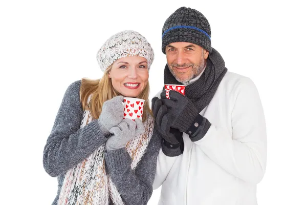 Casal feliz no inverno moda segurando canecas — Fotografia de Stock