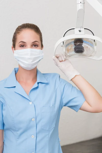 Asystent dentystyczny w maskę trzyma światło — Zdjęcie stockowe