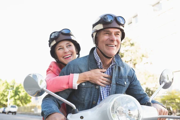 Feliz casal sênior montando um ciclomotor — Fotografia de Stock