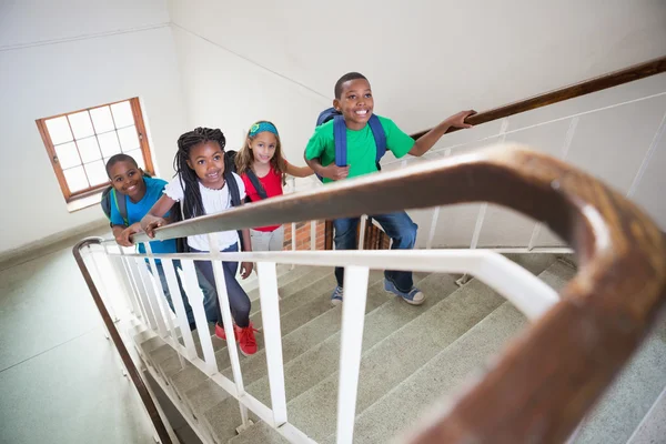 Cute pupils walking up stairs — Stock Photo, Image