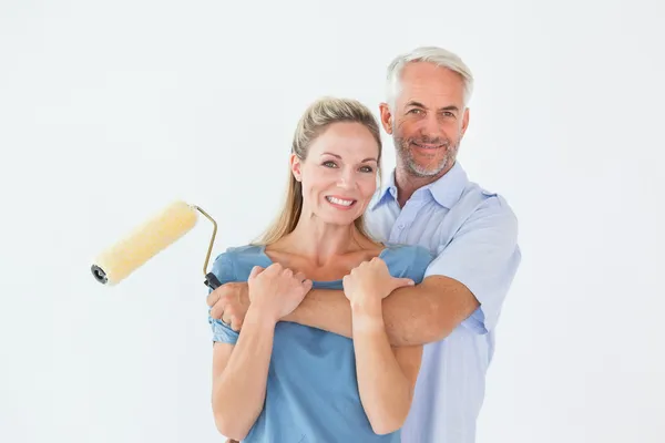 Happy couple hugging and holding paint roller — Stock Photo, Image