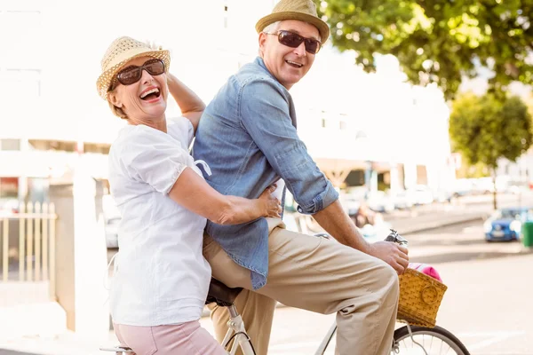 Feliz casal maduro indo para um passeio de bicicleta na cidade — Fotografia de Stock